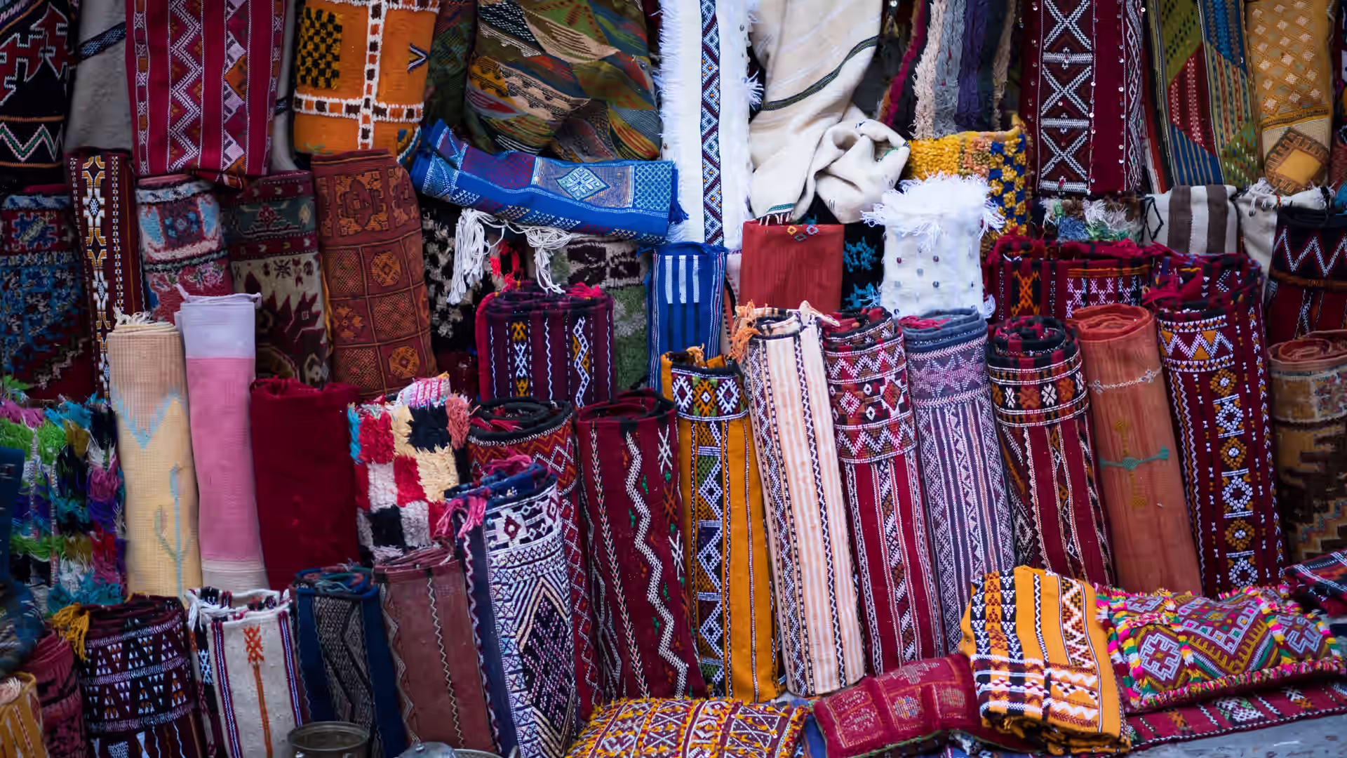 Alfombras bereberes de colores apiladas en un puesto del zoco