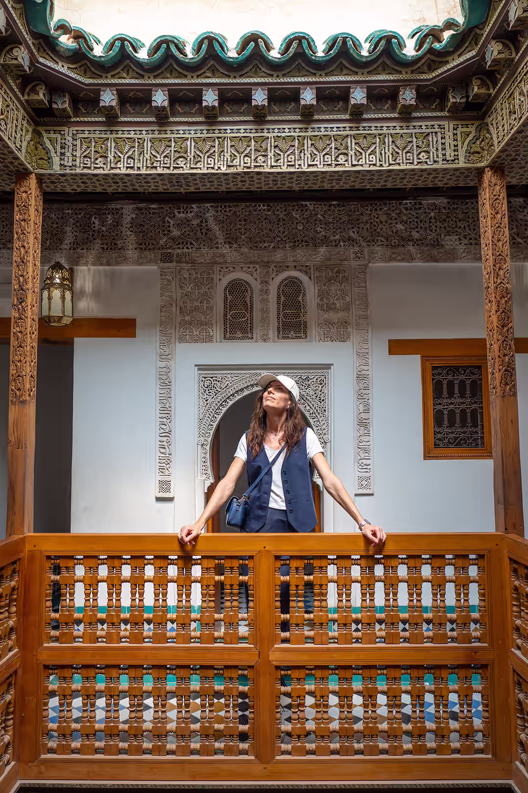 Viajera en el balcón ornamentado de un riad tradicional marroquí