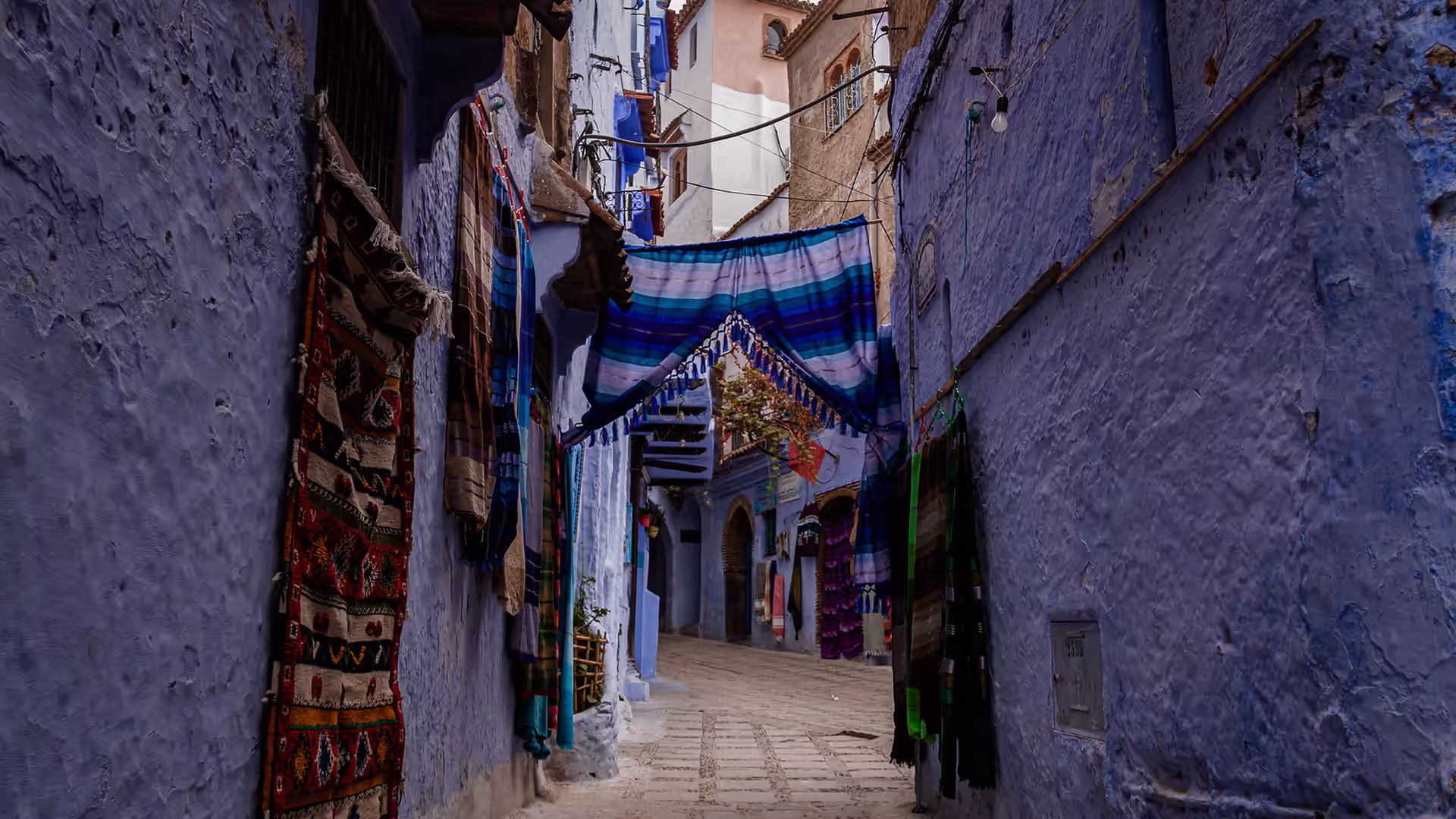 Callejón azul de Chefchaouen con alfombras de dibujos tradicionales