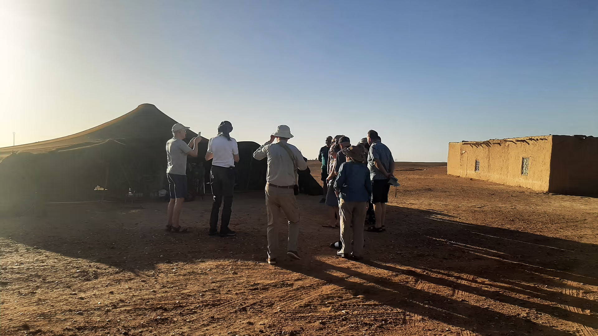 Viajeros visitando una jaima nómada tradicional a las afueras del desierto
