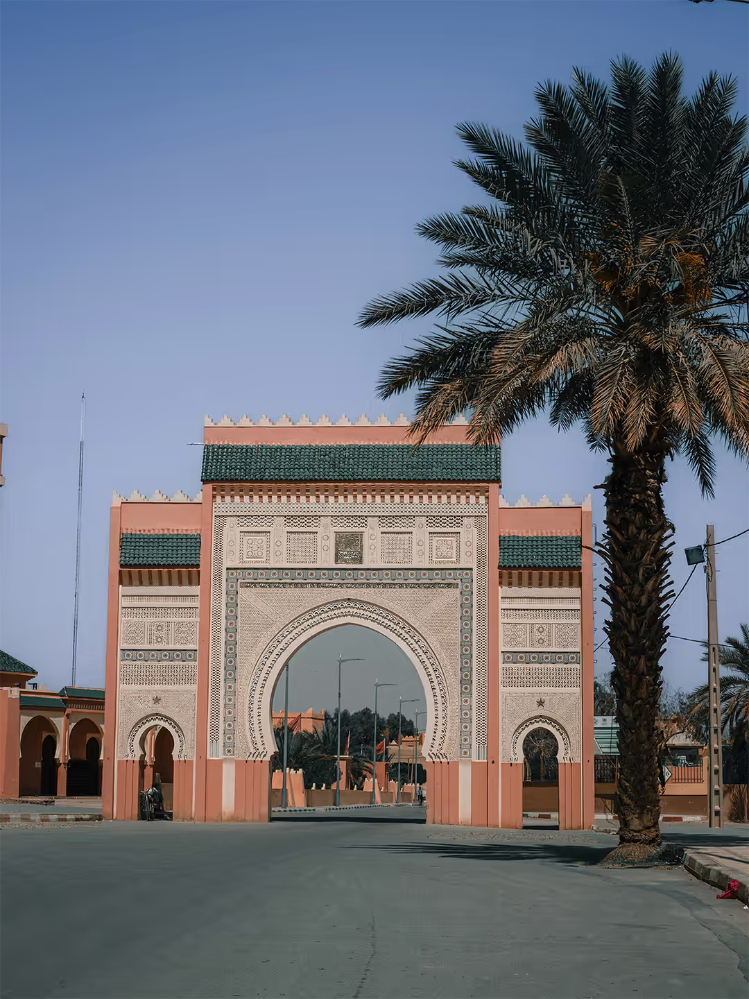 Gran puerta de entrada a Rissani con decoración tradicional y palmera